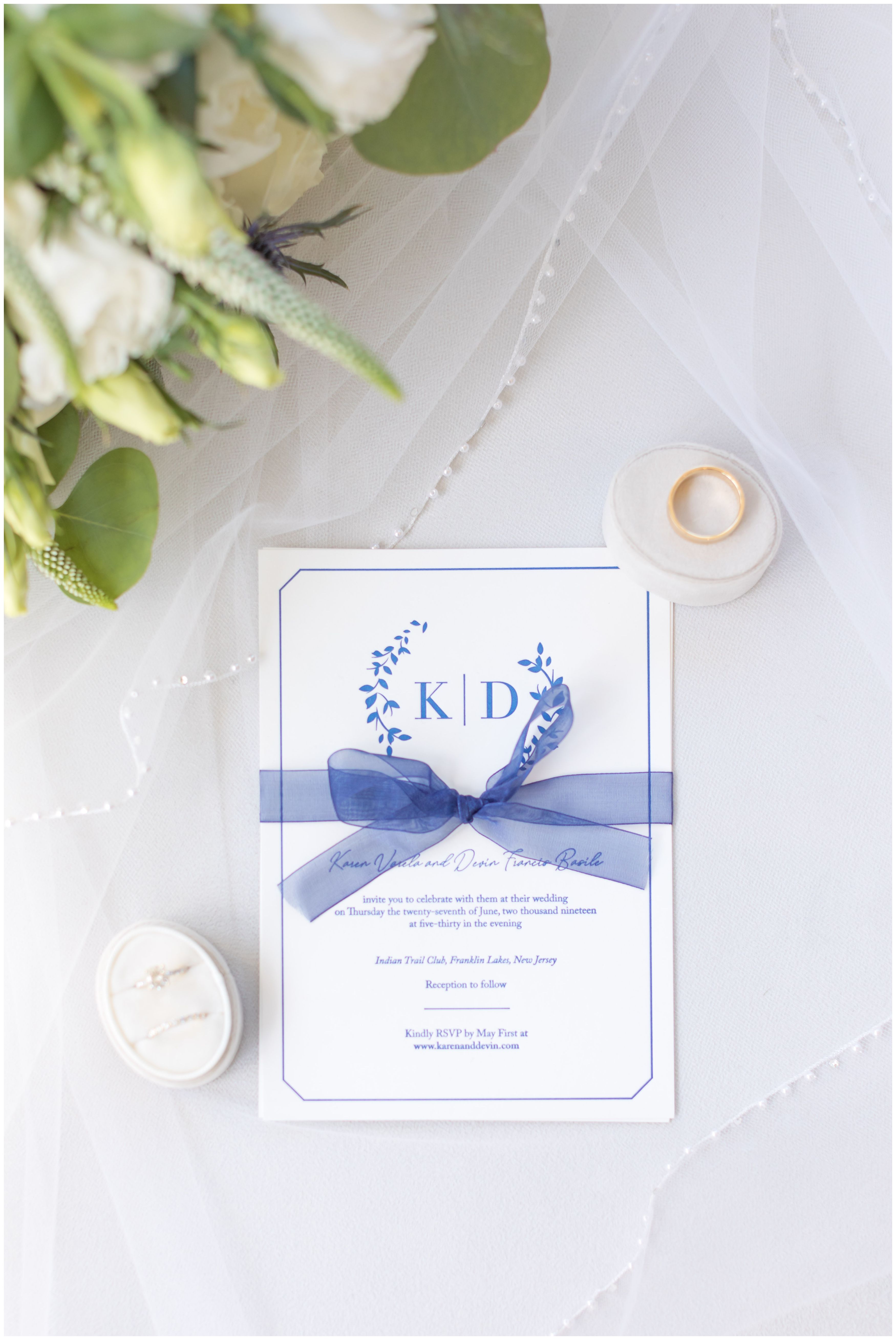 Elegant navy letterpress wedding invitation with wedding rings and bridal bouquet