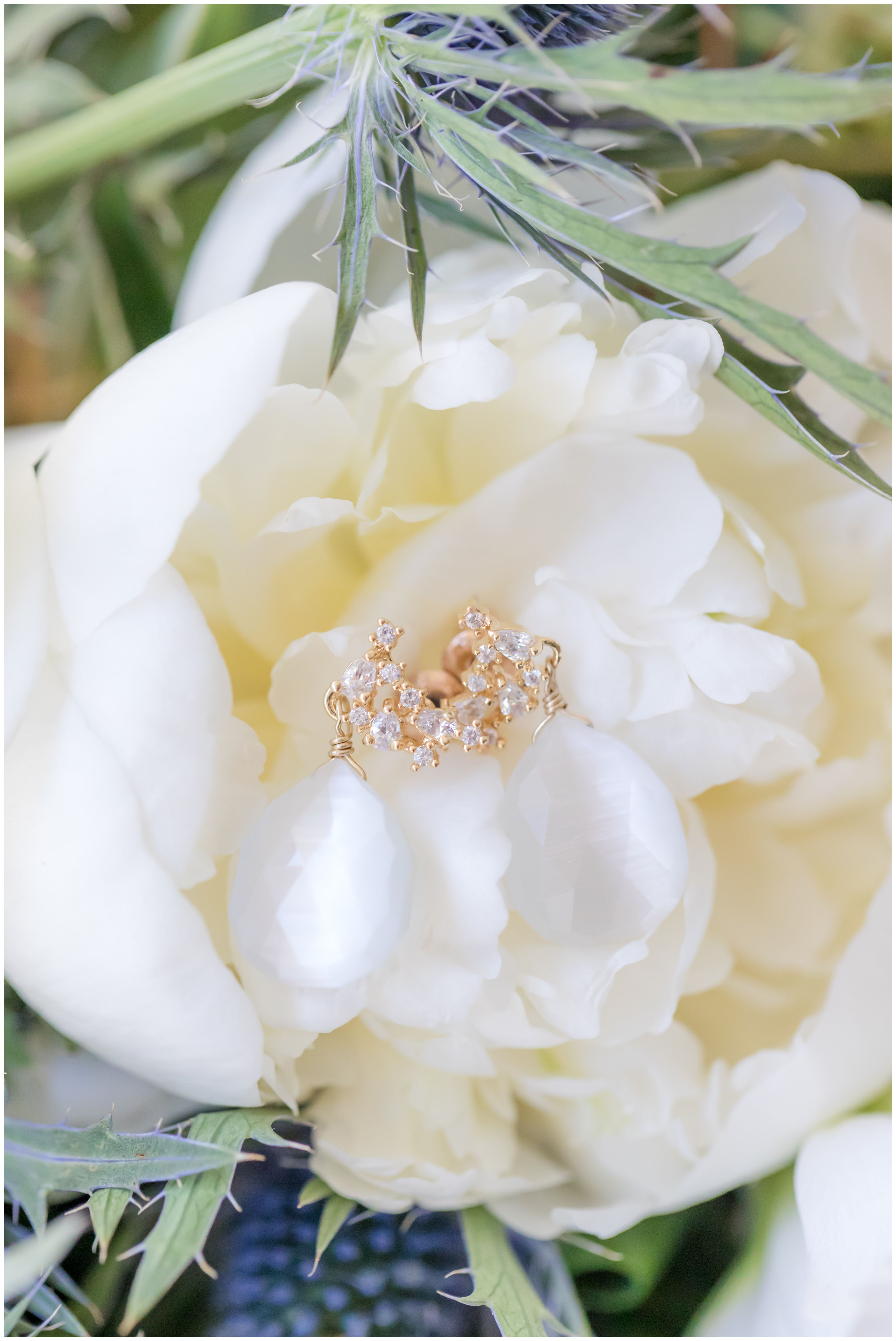 Gold diamond wedding earrings in white peony bridal bouquet