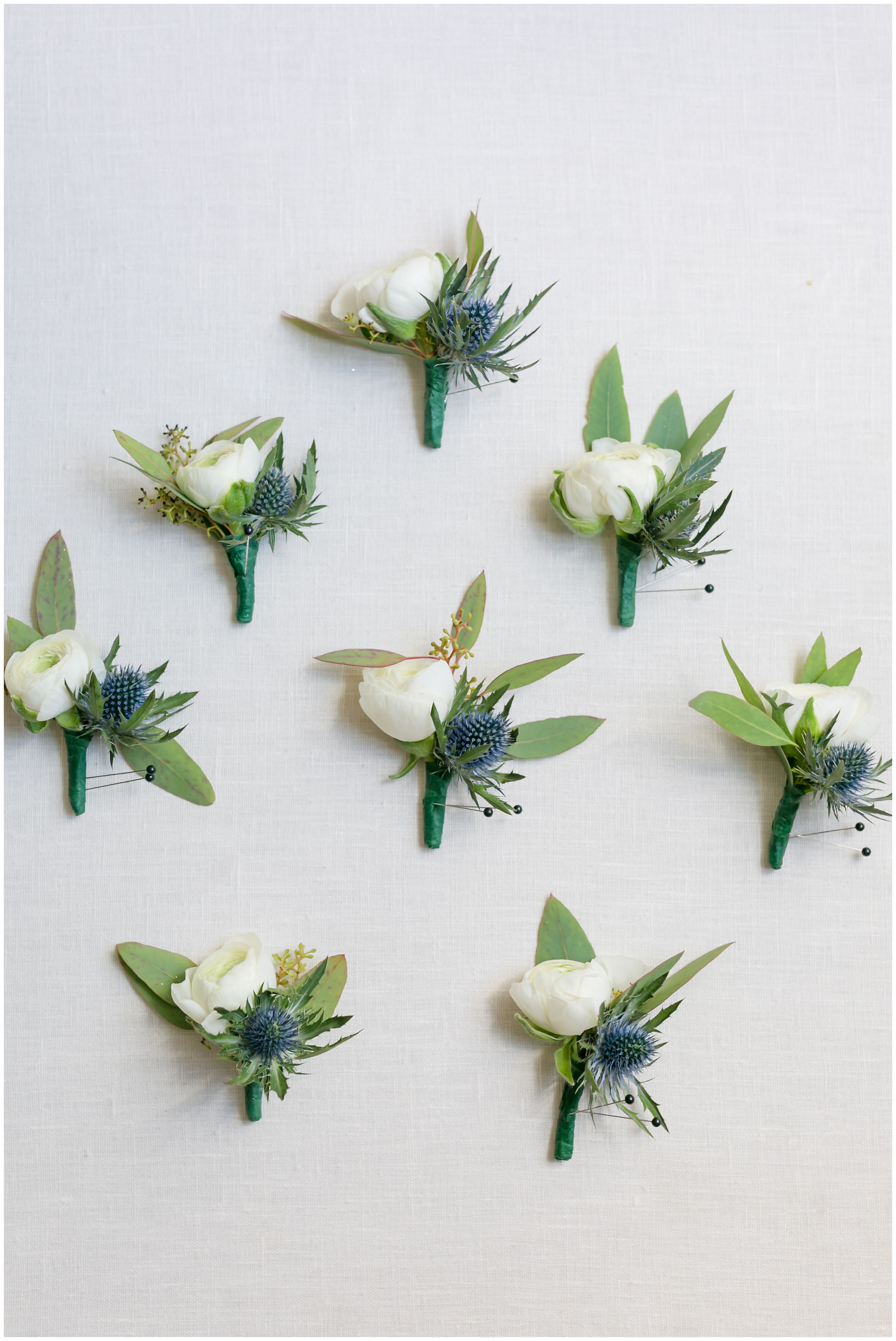 White peony boutonnieres for groom and groomsmen