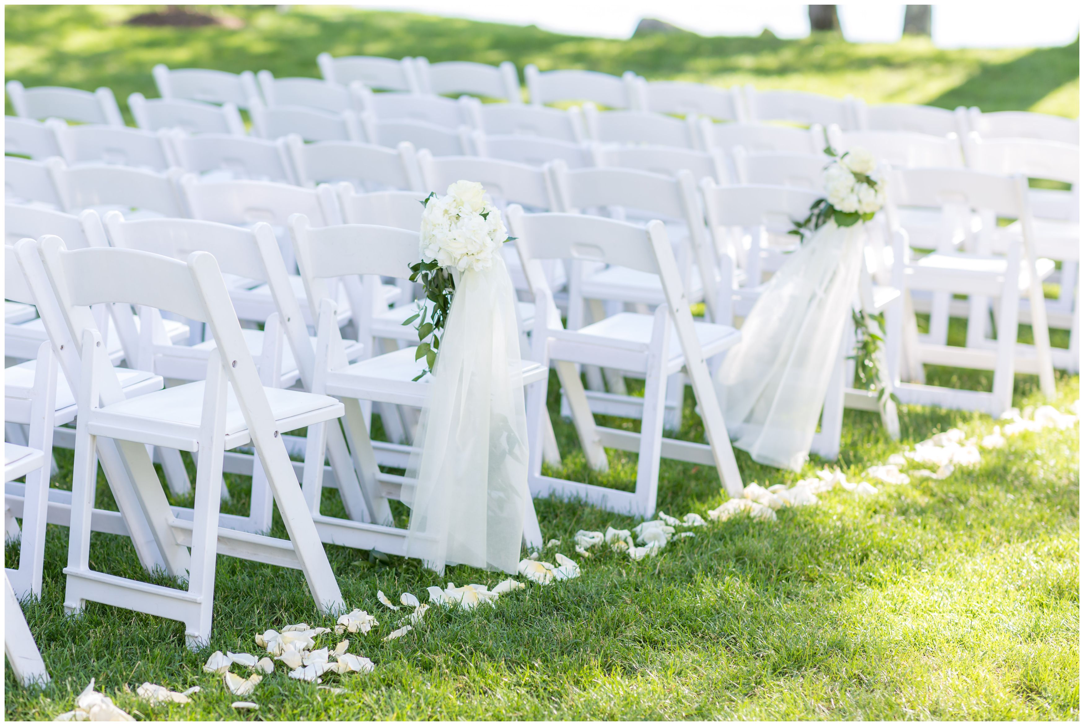 White floral ceremony details at an outdoor lakeside ceremony