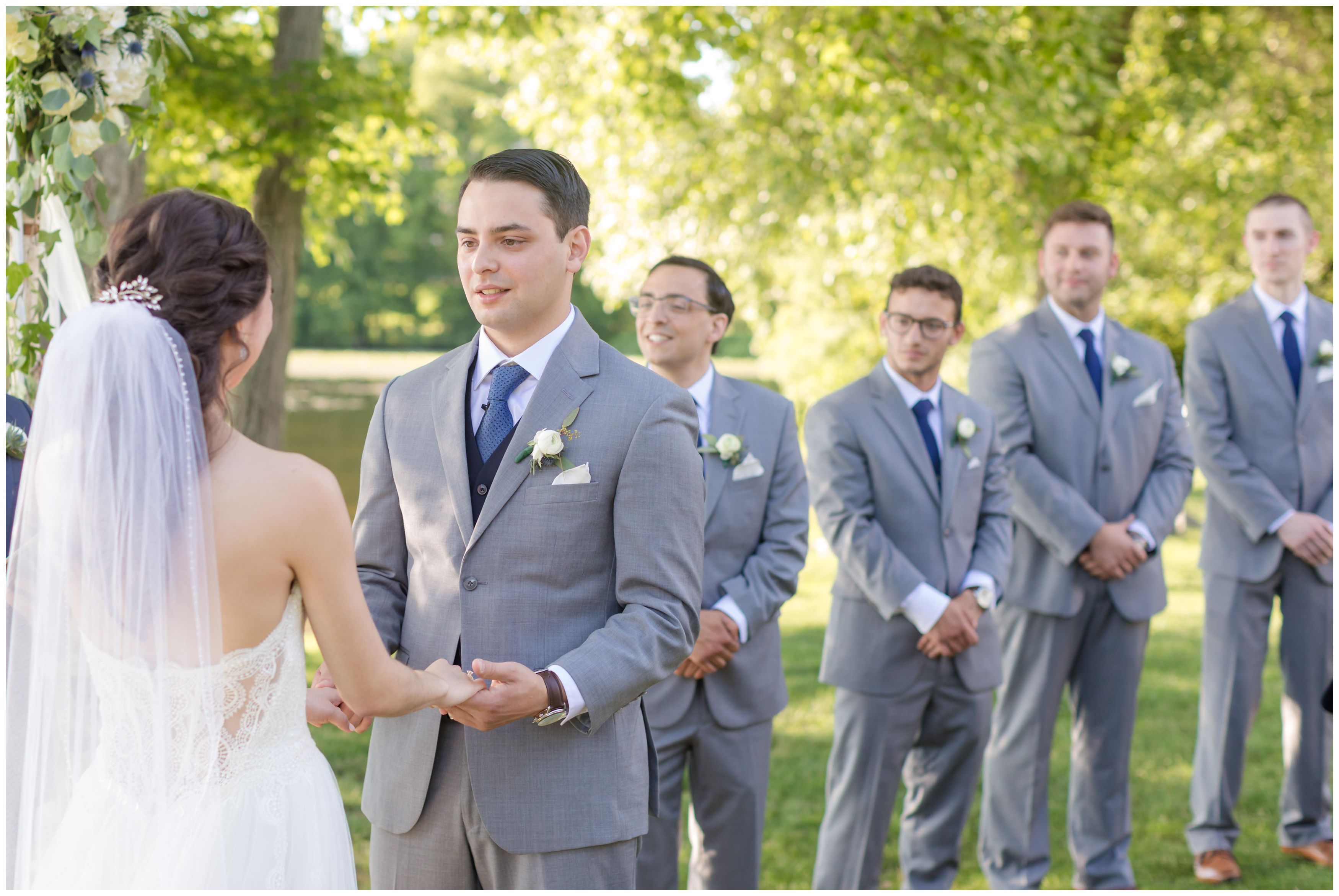 Groom looking at bride at outdoor lakeside ceremony
