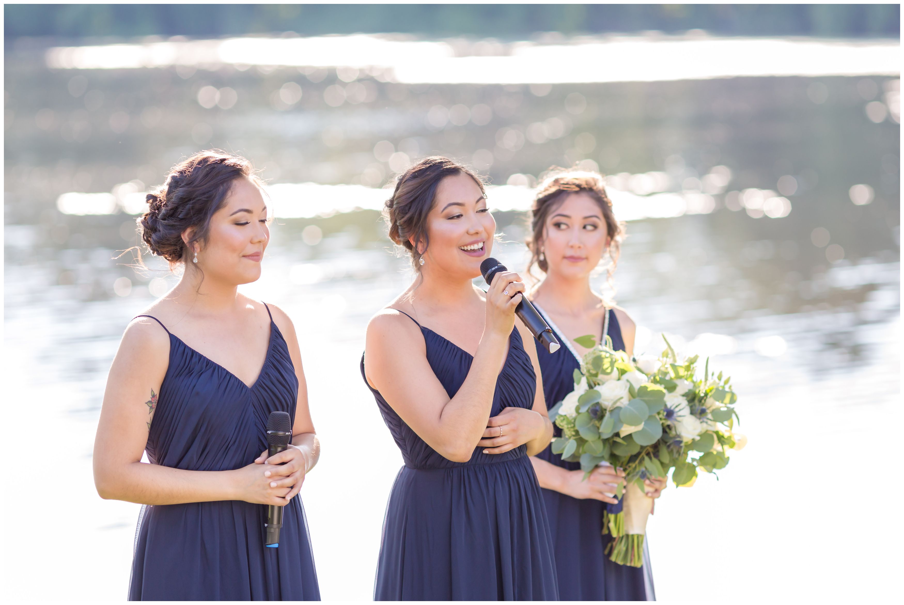 Sisters singing at outdoor lakeside ceremony
