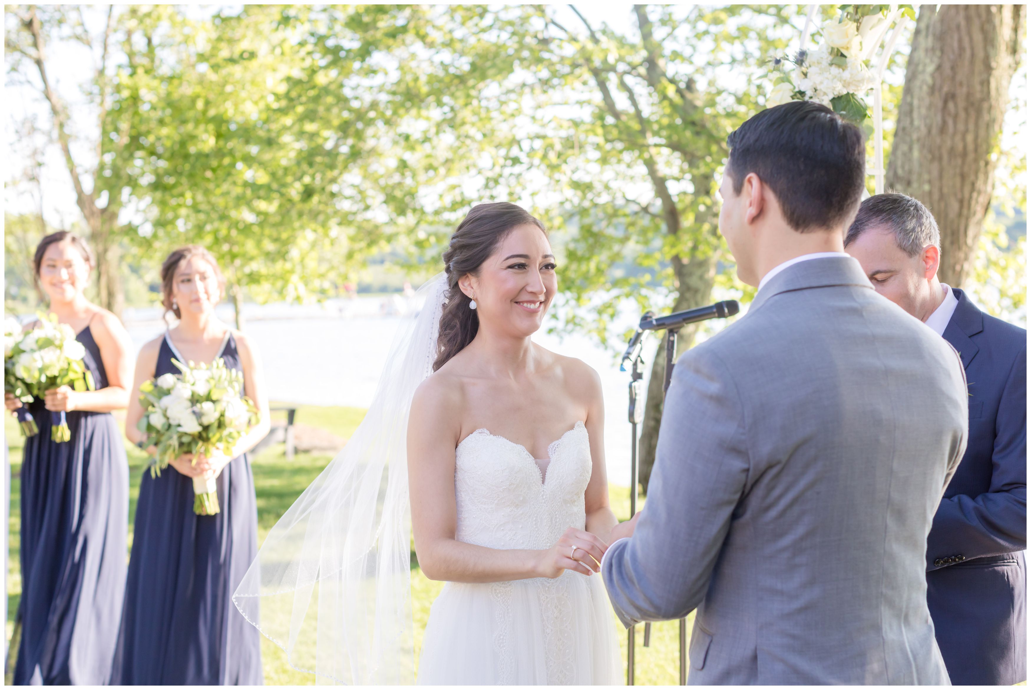 Bride saying vows at outdoor lakeside ceremony