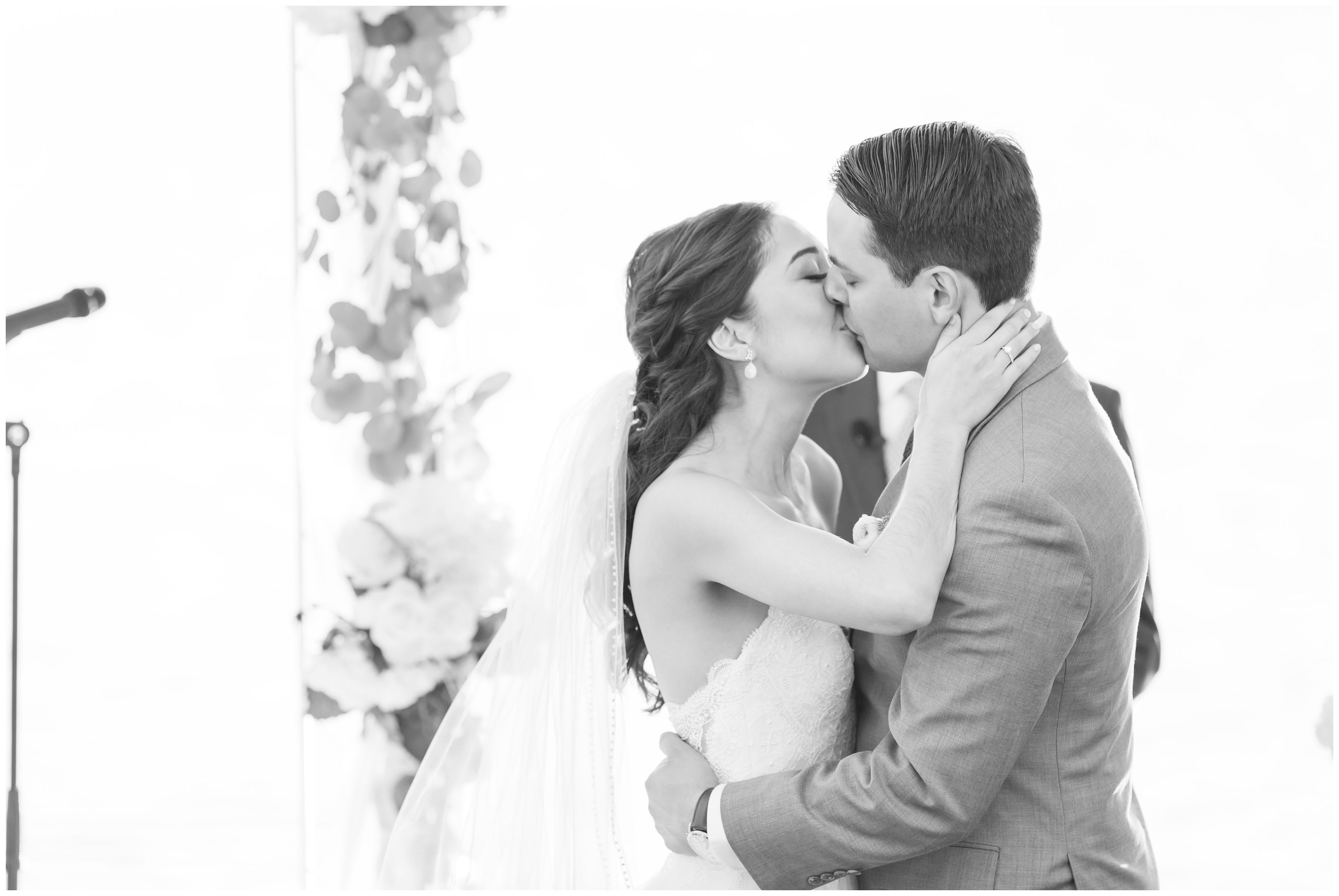 Black and white first married wedding kiss at outdoor ceremony