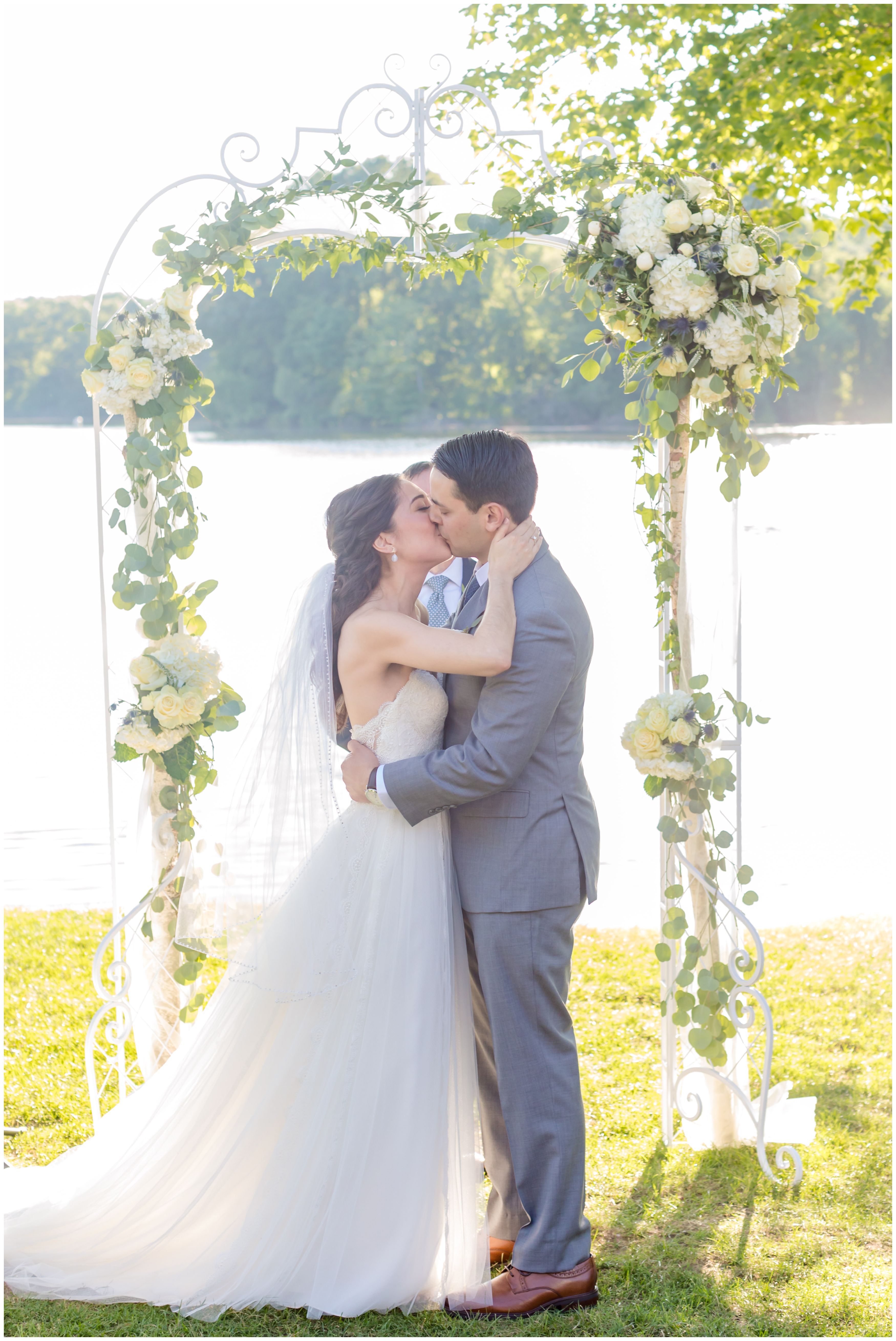 First ceremony kiss at outdoor lakeside ceremony at Indian Trail Club