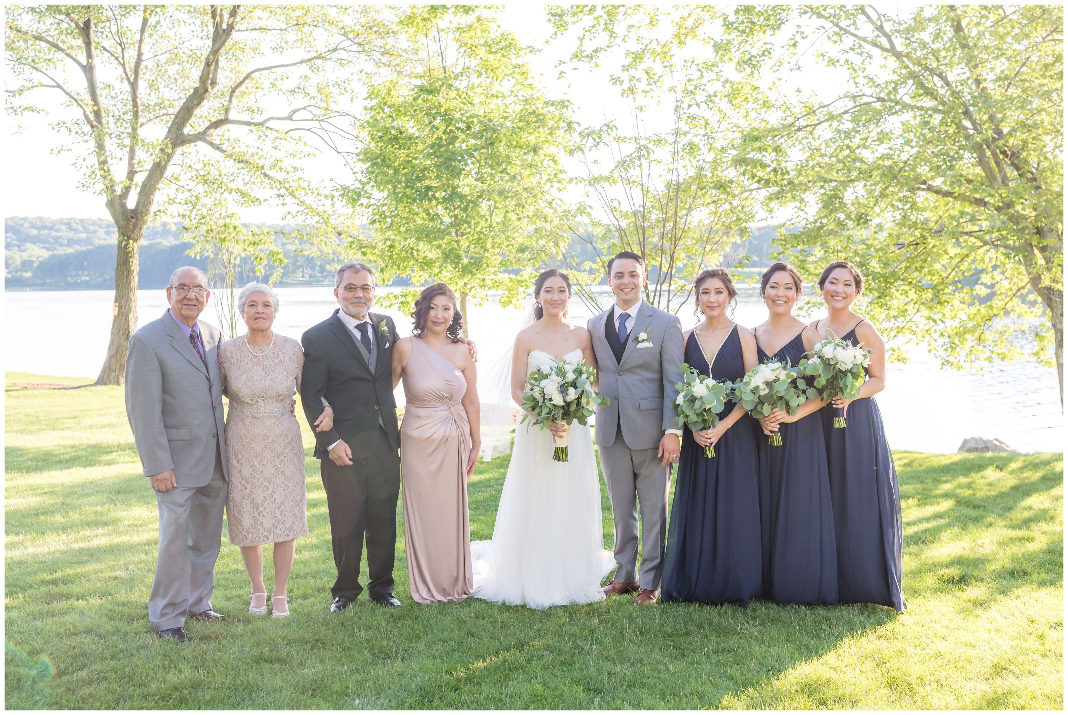 Bride and groom and bride's family at outdoor lakeside wedding