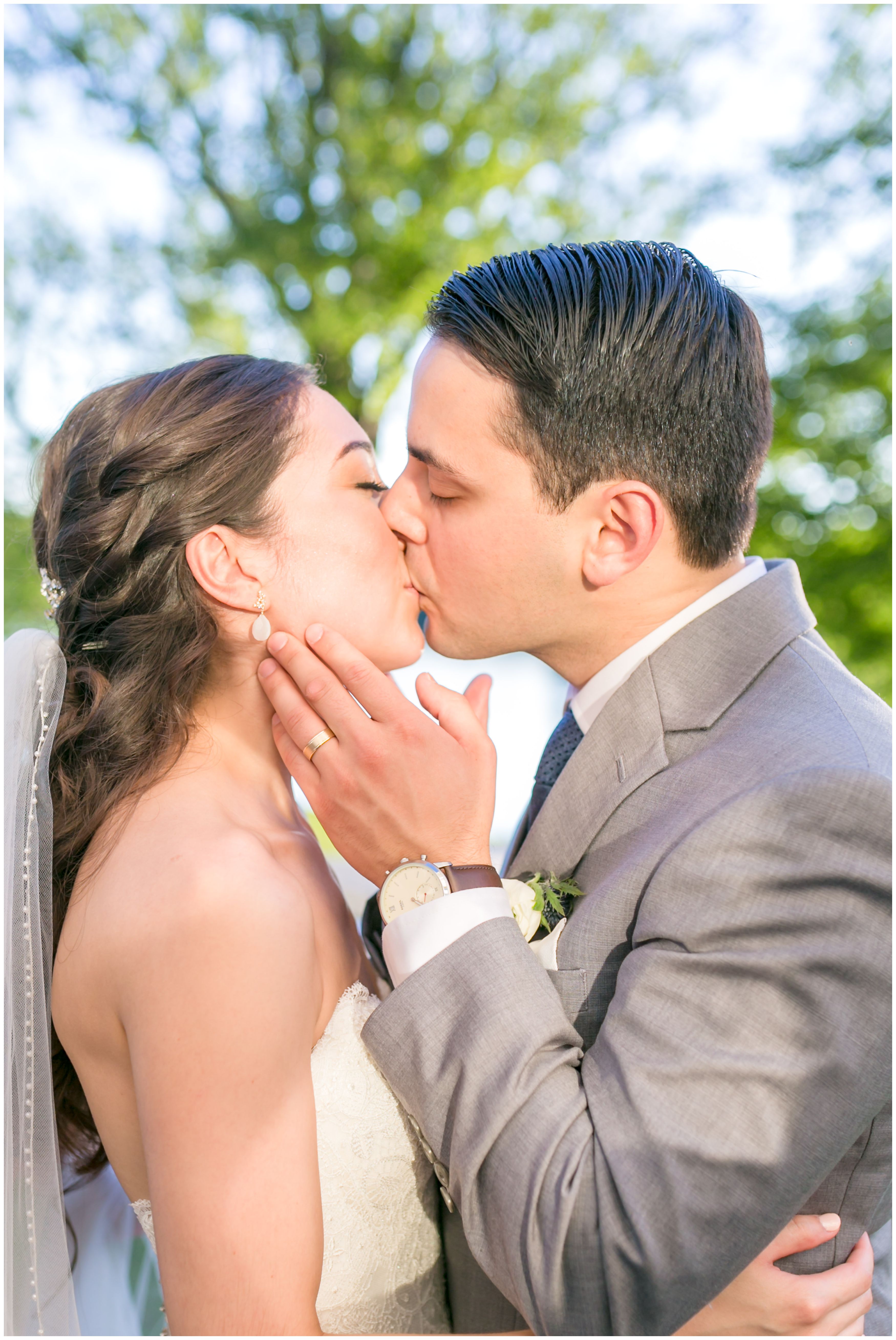 Bride and groom portrait kiss at outdoor lakeside wedding