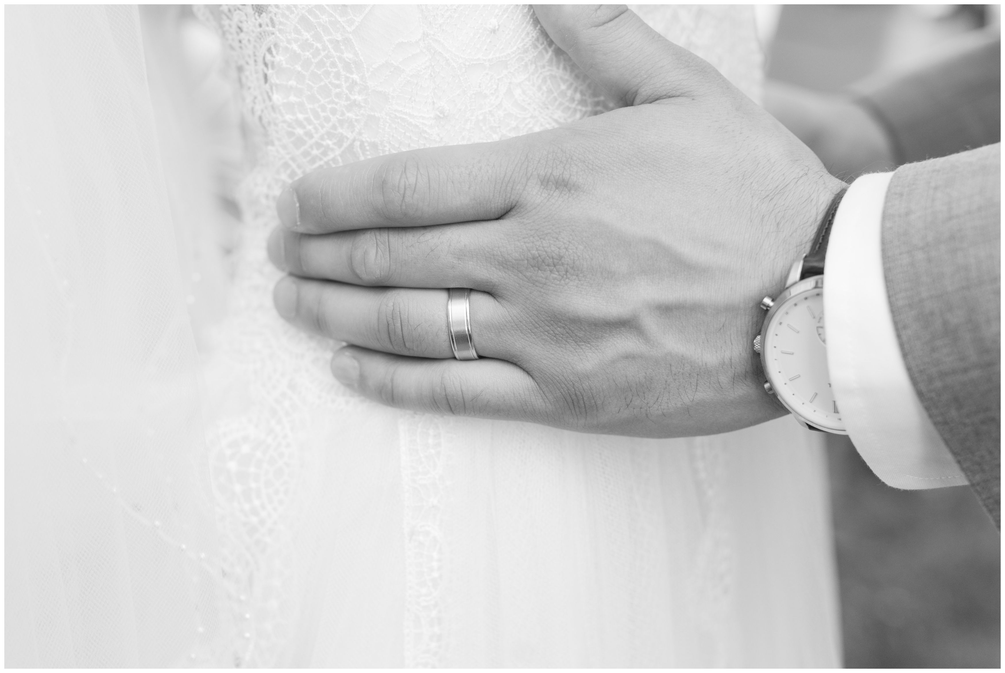 Bride and groom portrait black and white, grooms hands holding brides waist