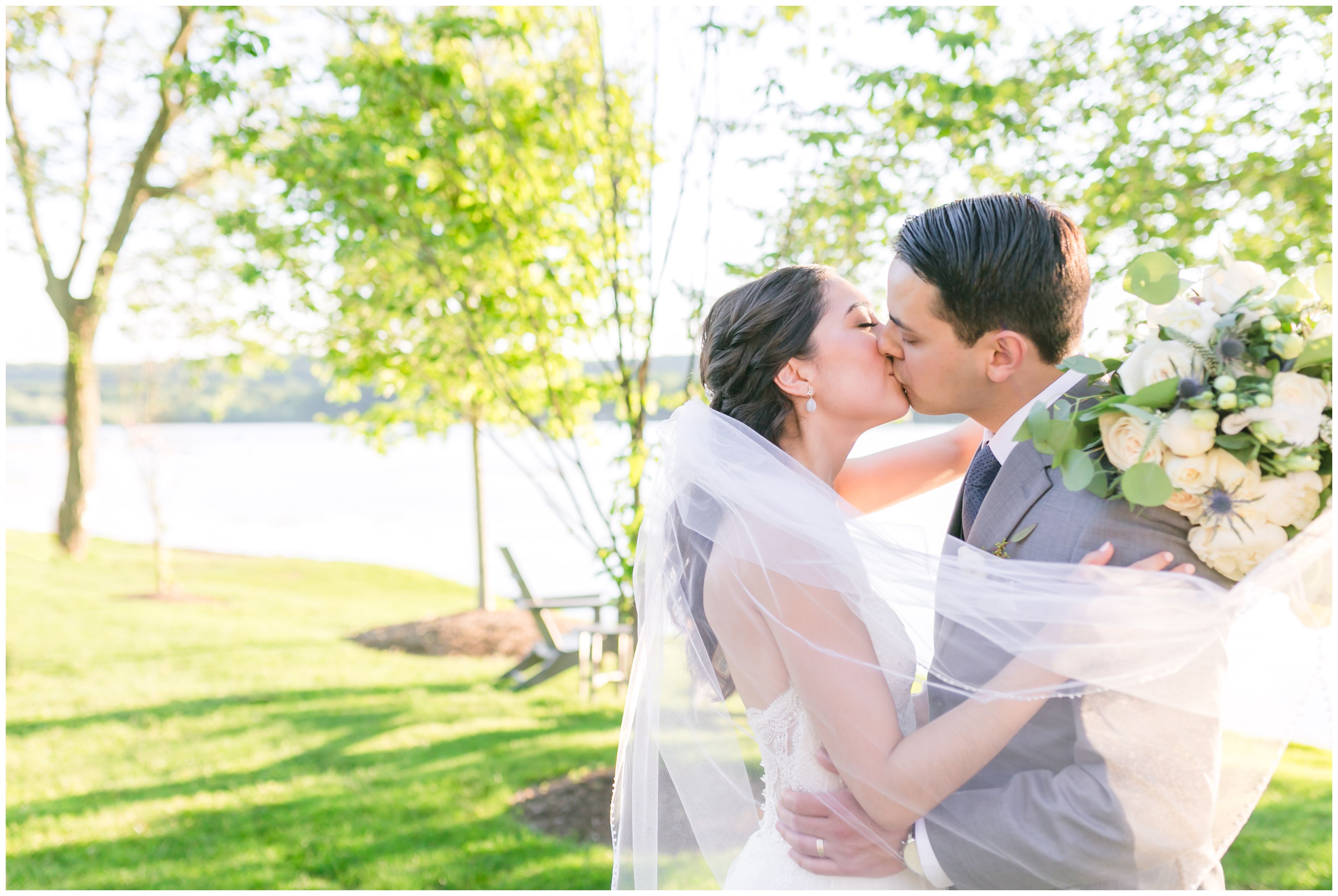 Classic bride and groom wedding portrait kissing at outdoor summer lakeside wedding at the Indian Trail Club